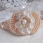 Bracelet Bouquet d'un Jour brod&eacute; avec un cabochon rond couleur Ivoire, fleurs en Lucite entrelac&eacute;es avec des rocailles, toupies en Cristal et Light Peach de qualit&eacute; AB2X &agrave; laquelle s'ajoute des rubans